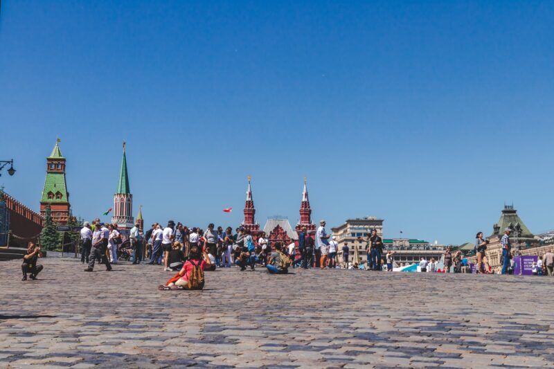 vojna na Ukrajine - people walking on a city square under clear blue sky