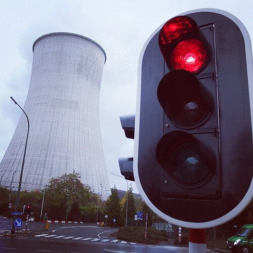 semafor s červeným svetlom, v pozadí jadrová elektráreň